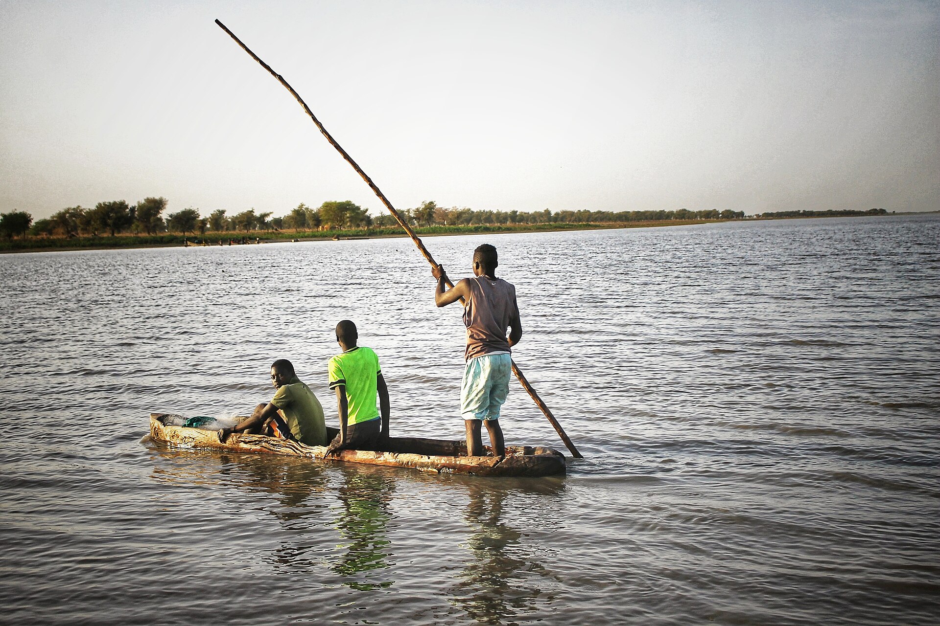 Pêcheurs sur une pirogue au milieu d'un plan d'eau